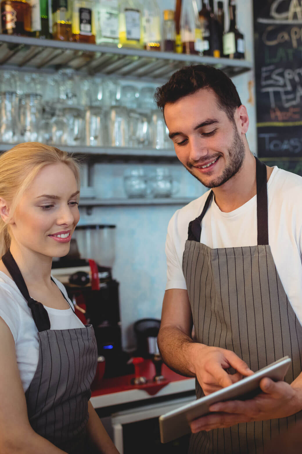 To cafémedarbejdere som benytter Nem Booking bordbookingsystem på tablet